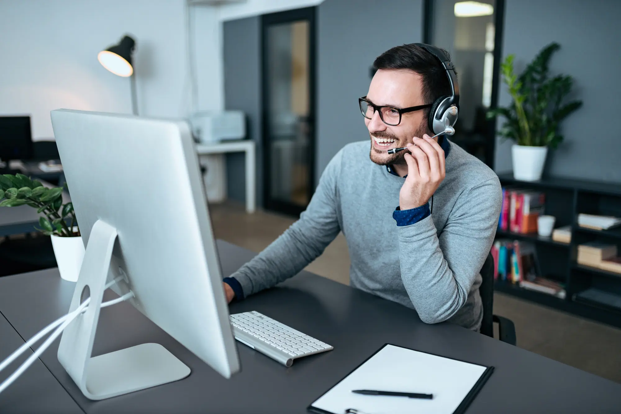 Support agent wearing a headset speaking with a client